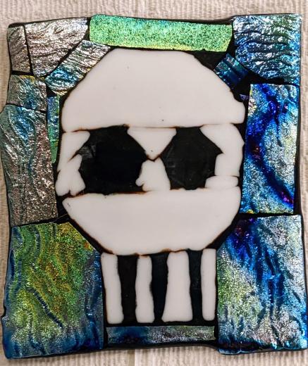 fused glass with skull surrounded by iridescent glass