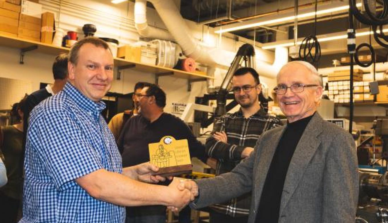 Mark Belanger, manager of the Edgerton Student Shop, accepts the plaque acknowledging his 15 years of service to students from Professor J. Kim Vandiver, Forbes Director of the Edgerton Center.