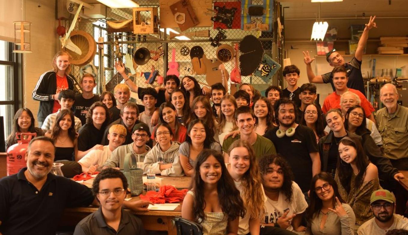 Group of 40 students and mentors smile together in the Edgerton Center Student Project Lab makerspace