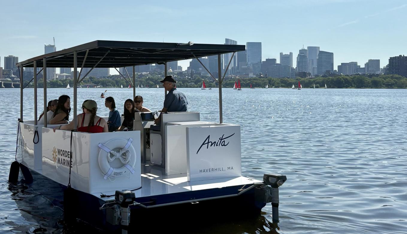 Two-hulled boat with solar panel roof cruises on the Charles River