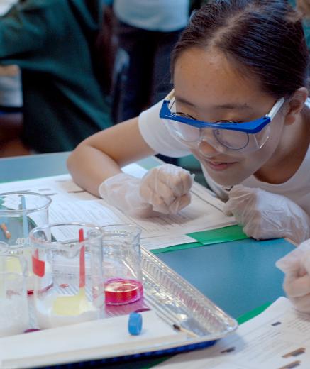 chemicals in beakers observed by a young woman