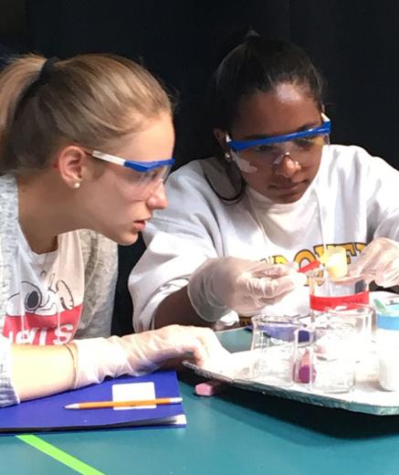two girls performing chemical reaction