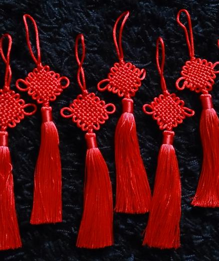 a series of eight traditional decorative Chinese knots with tassels