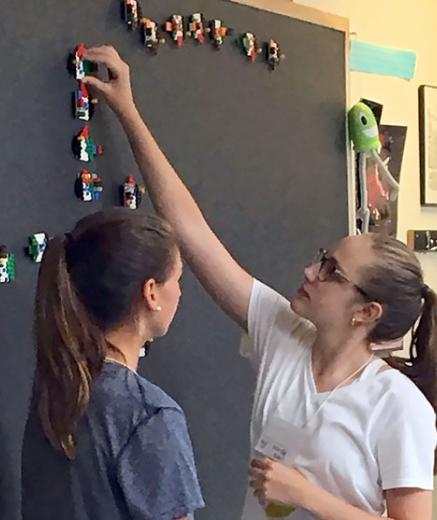 two girls at a blackboard with LEGO fish