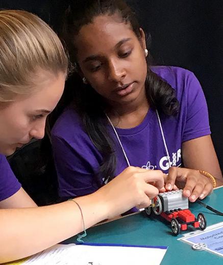 Two girls working on a motorized LEGO car