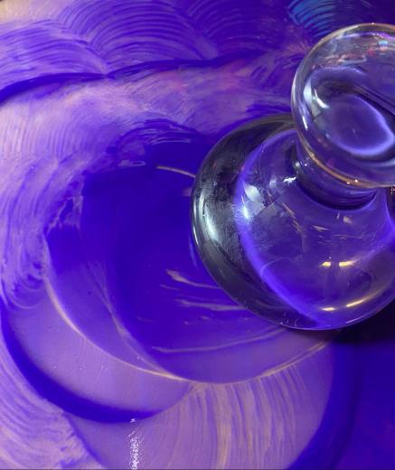 glass item swirling purple paint on a surface