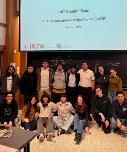 Satellite Team members pose in front of a projector screen