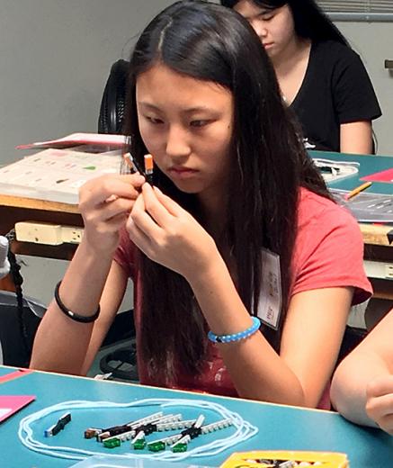 girl assembling LEGO model of sister chromatids
