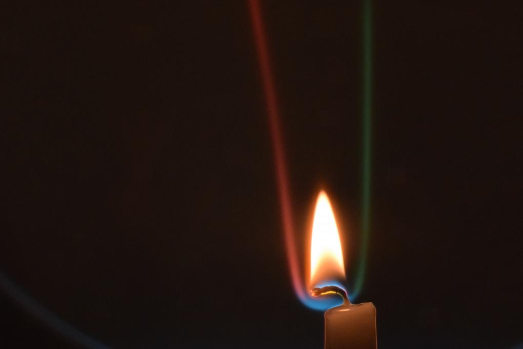 This Schlieren image of a lit candle in still air shows the edges (red and green) of the column of hot air rising from the candle. The colors on the top (blue) and bottom (yellow) of the wick show that it is colder than the air surrounding it.
