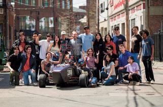 2024 MIT Motorsports Team with their electric race car at an Edgerton Center Showcase