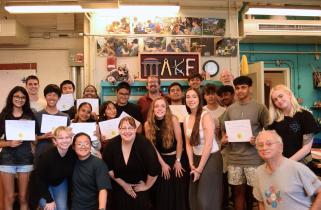 Edgerton Hackathon Challenge participants hold their certificates and smile in the 4-409 Makerspace