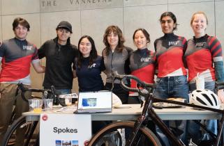 Members of MIT Spokes pose, some in team jerseys, behind their bicycles