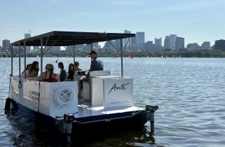Two-hulled boat with solar panel roof cruises on the Charles River