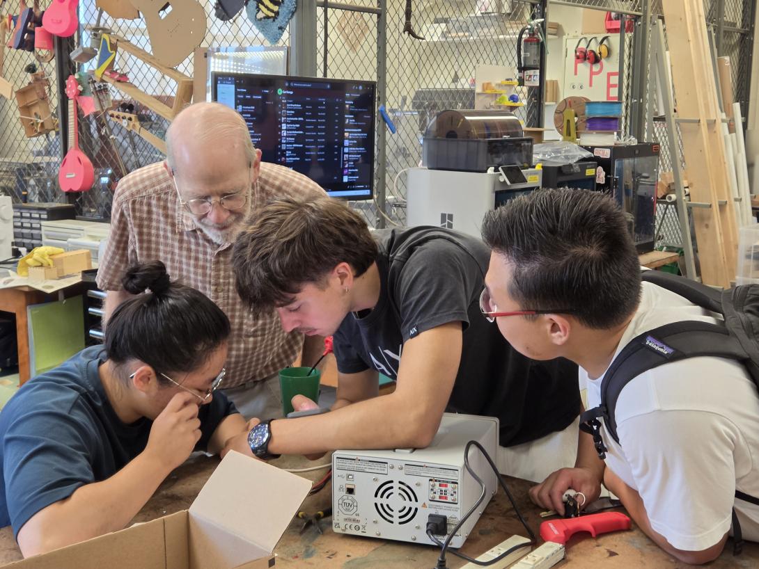 Students and mentors gather around electronics components