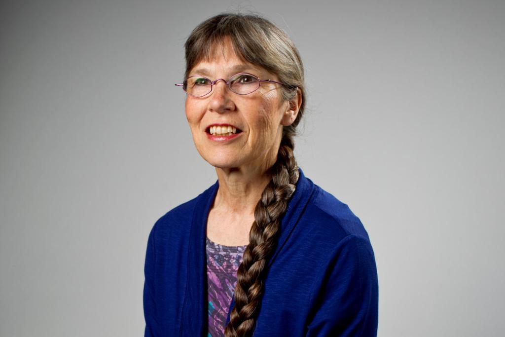 Kathy Vandiver poses in front of a gray background