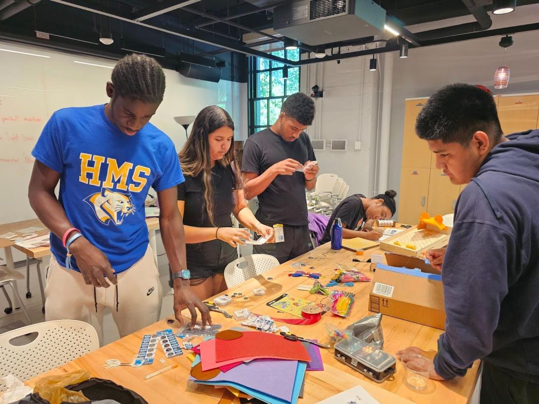 students stand around a table with craft supplies
