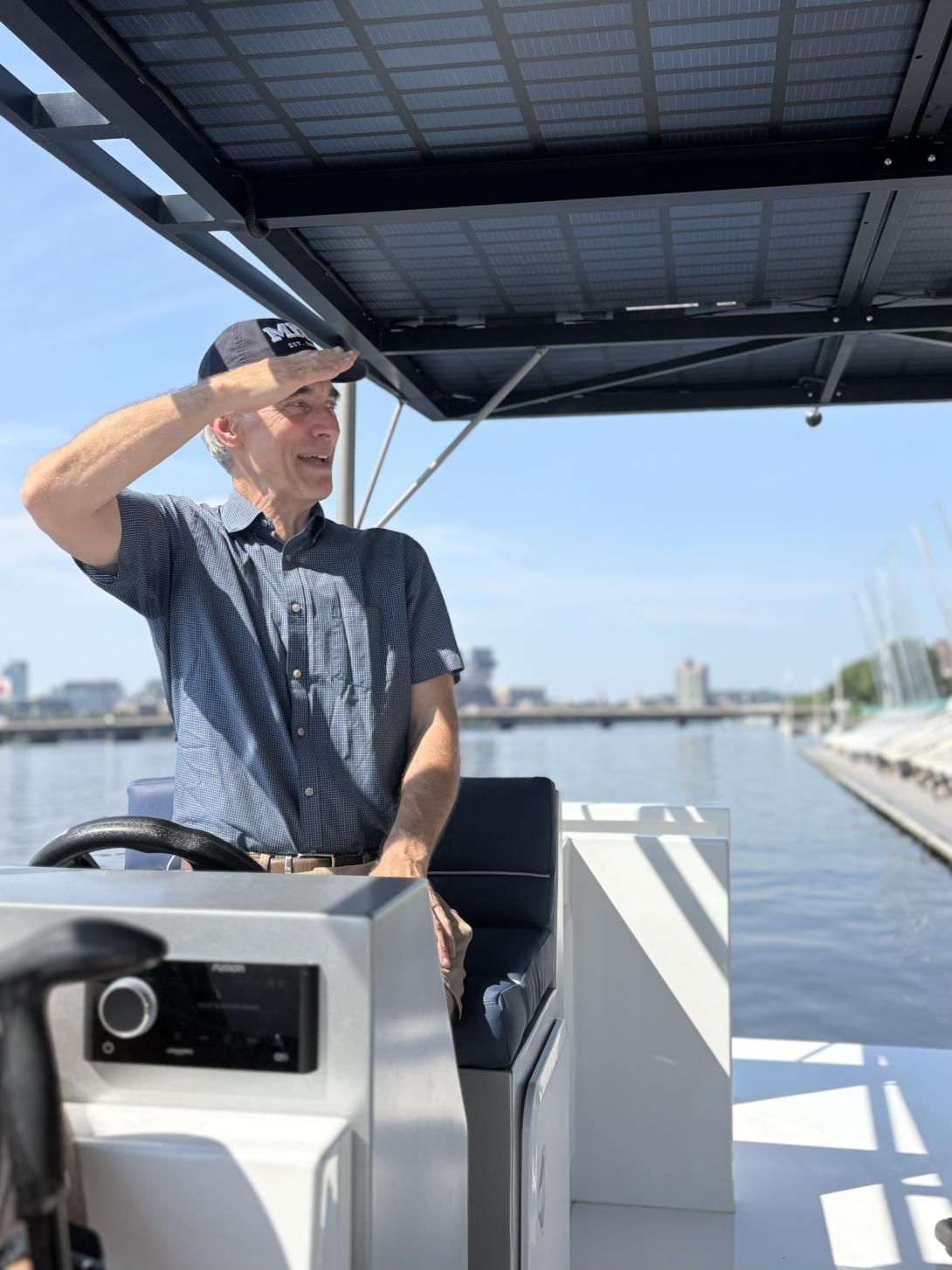 James Worden '89 salutes from the helm of a solar-powered catamaran.